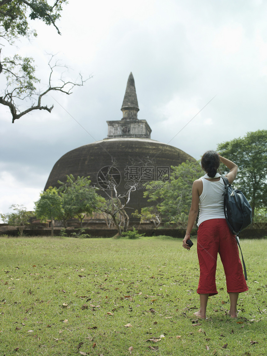一名年轻女游客全长后方观光 观看Stupa图片