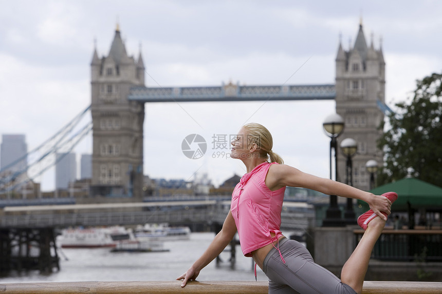 妇女伸展在大塔桥前 在英国伦敦头发国际位置服装微笑地标成年成人城市一人图片