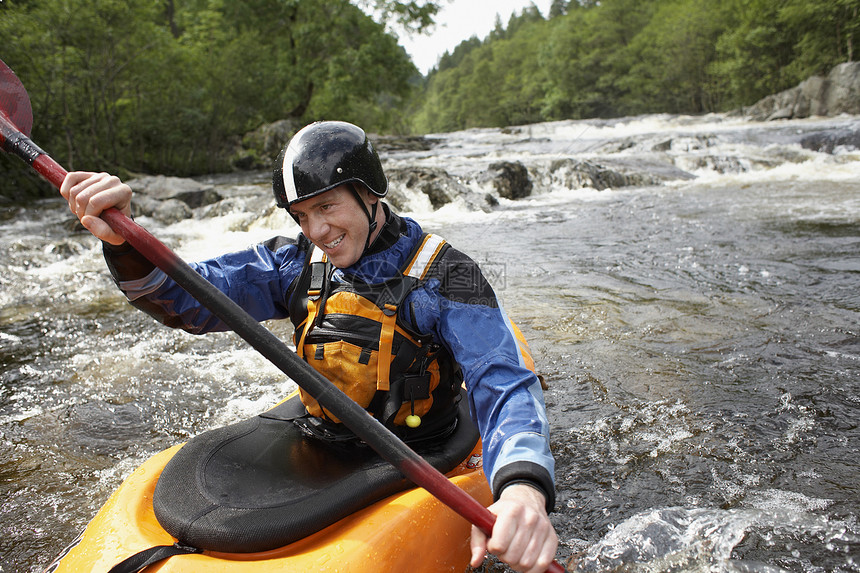 微笑的年轻人在河里用皮艇划艇危险成人乐趣享受冒险男人娱乐裁剪挑战救生衣图片