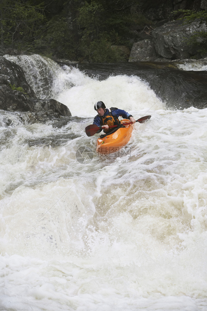 在粗河中看到一条人皮艇橙子头盔活动冒险白水成人乐趣夹克行动风险图片