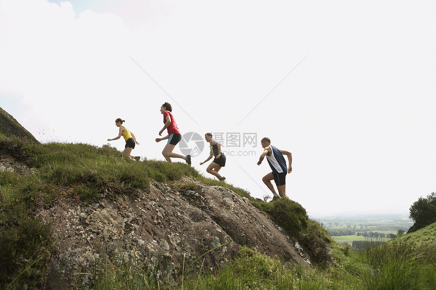 一群人在山上奔跑的侧面景象天空竞赛运动服远足者团结探索者旅行运动训练男士图片