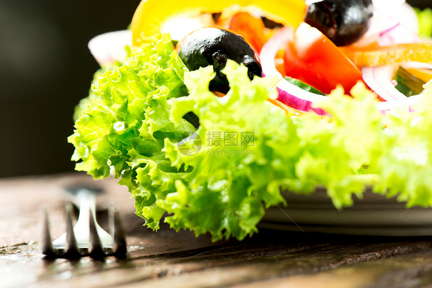 沙拉 蔬菜和绿菜放在盘子里 叉子紧闭图片
