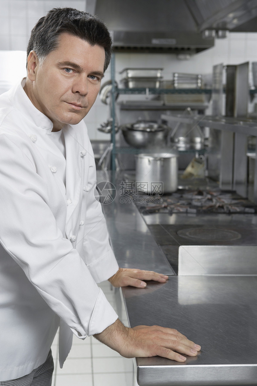 坐在厨房的一位自信男厨师的肖像工人职业制服职员男士中年工作服务男性工作服图片