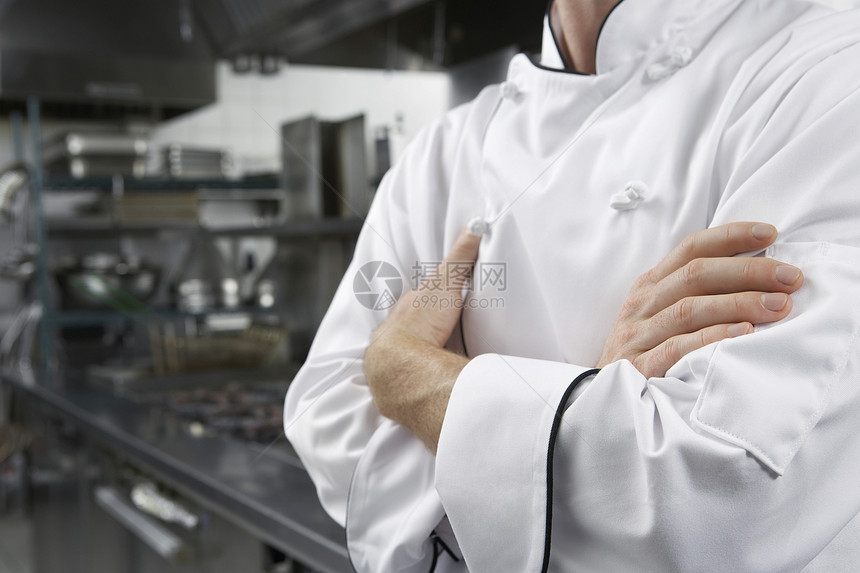 厨房中手交叉的男性厨师中近身部图片