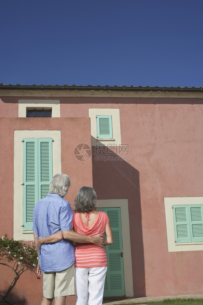 看见一对年老的情侣 手抱双臂站在家门前图片