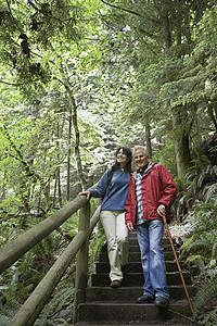 在森林足迹上行走的老年男子和中年妇女高清图片