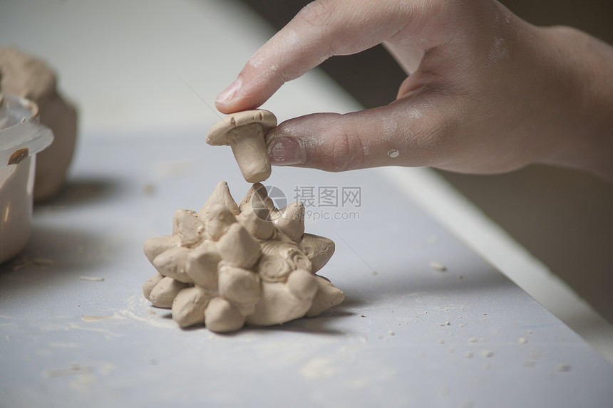 女孩用泥土做玩具车轮手工艺术家陶器商业女性学习陶瓷洞察力设计师图片