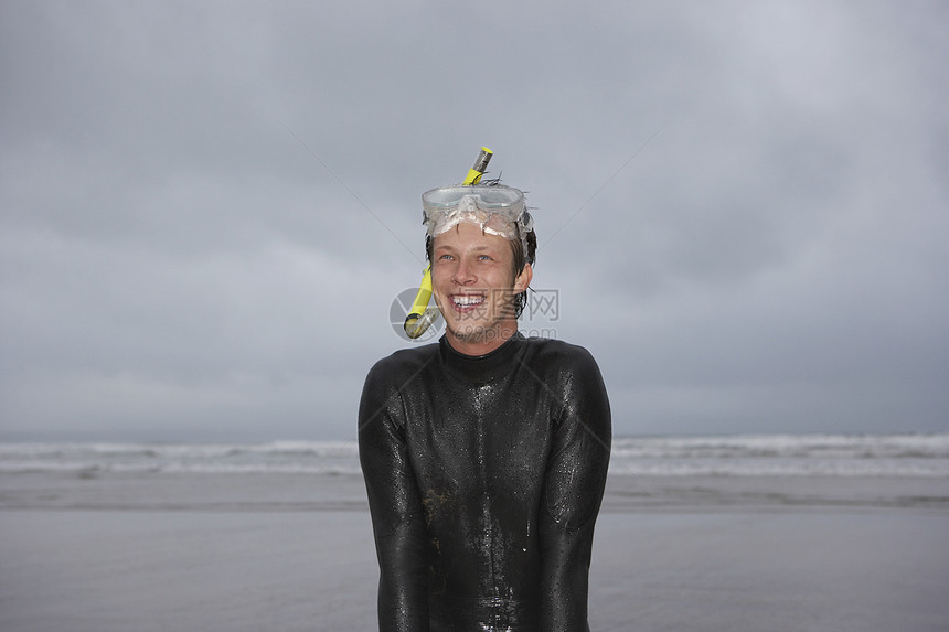 穿着湿衣服的男子 在沙滩肖像上站着海滩短发快乐微笑海洋摄影活动休闲地平线头发图片