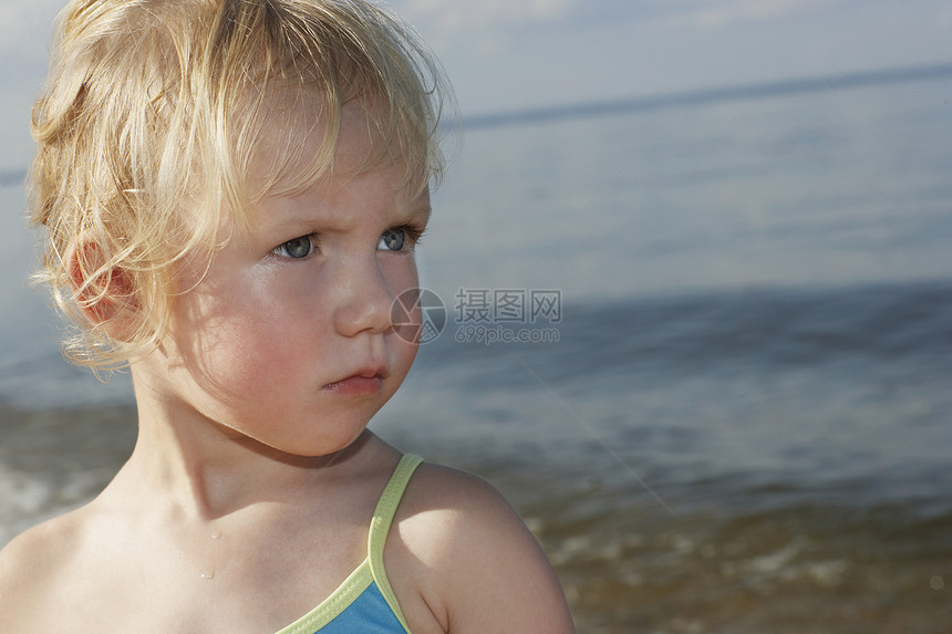 可爱小女孩的近身 在海滩看远处图片