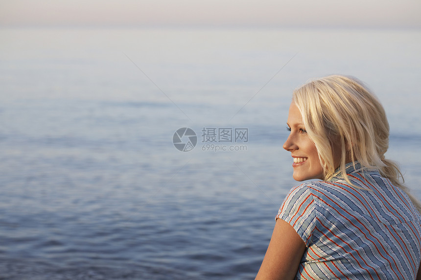 坐在沙滩上看一眼美丽的女人的近视图片