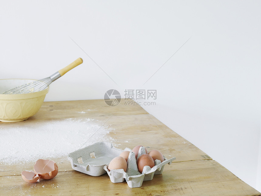 分散在桌上的碗蛋和面粉食材蛋壳桌子食物物体图片