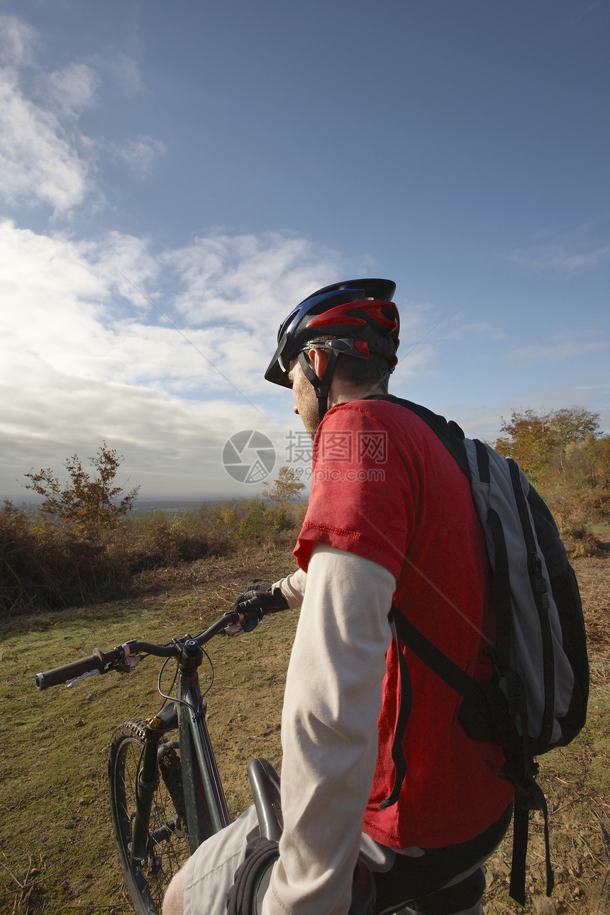山上骑自行车的年轻男子对农村风景的后视背包头盔活力成人闲暇男人男士天空冒险山地图片