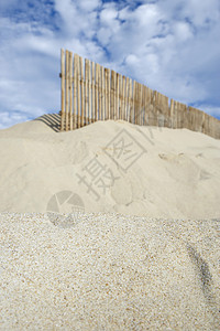 沙滩上篱笆在沙沙滩上对云端的天空设置木篱笆背景