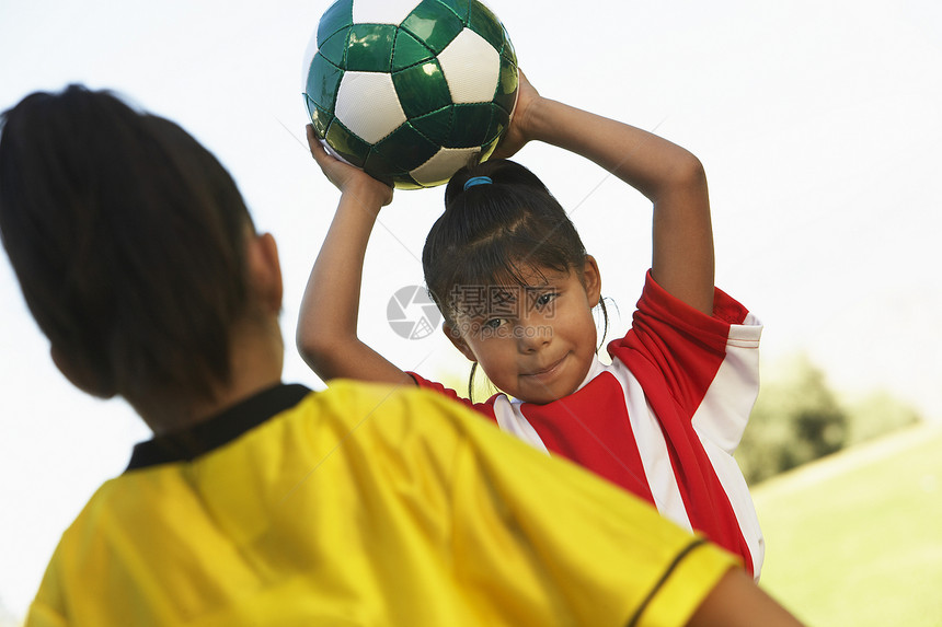女性球员即将与对立球队球员一起 在前台投足球赛图片