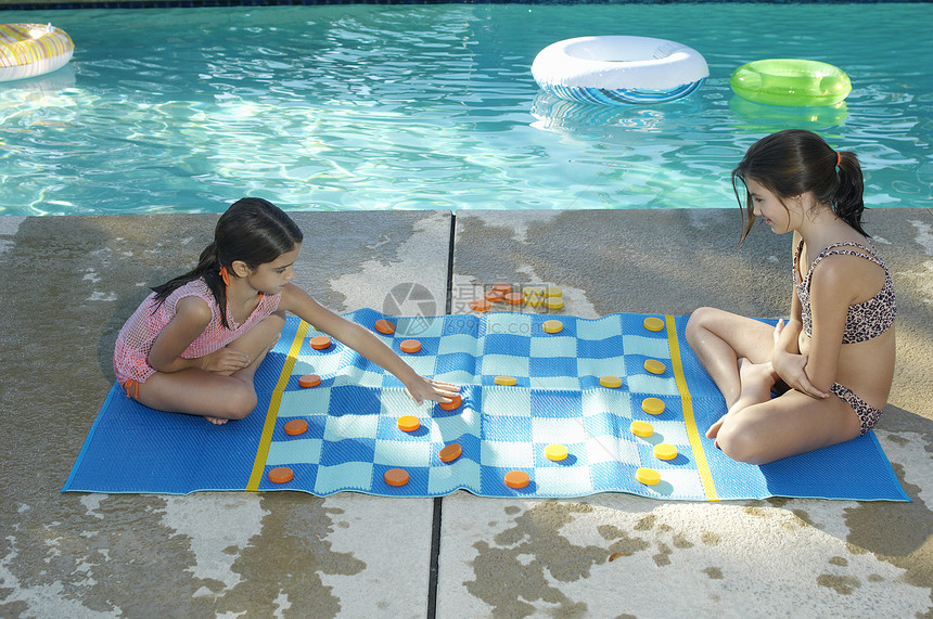 两个小妹妹在游泳池边玩大型拖拉机板图片