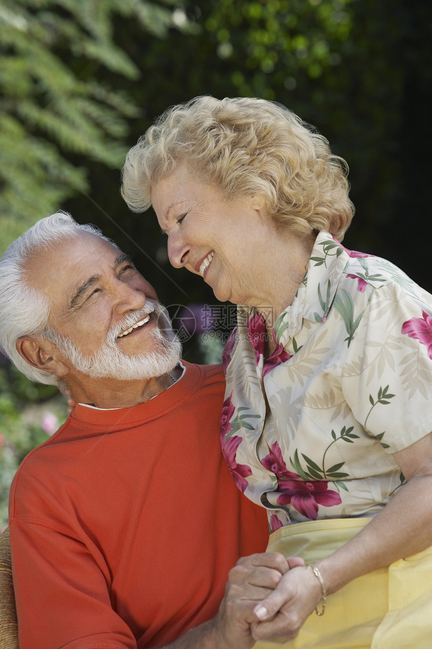 快乐的老年夫妇在花园休息时拥抱在一起图片