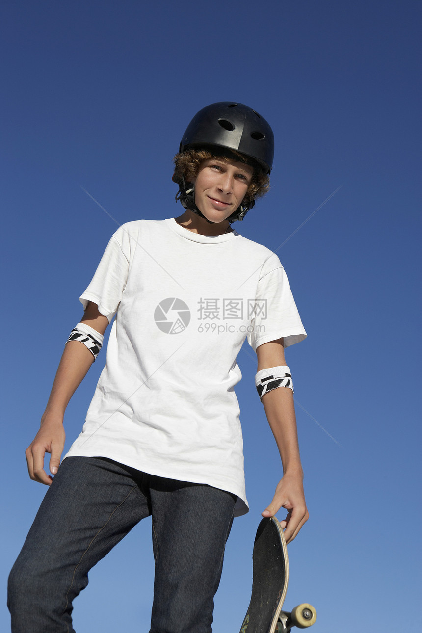 青少年男孩(16-17岁)在户外摆着滑板肖像图片