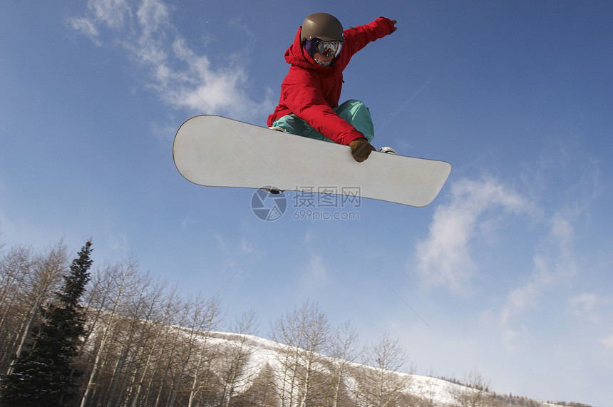 年轻男性滑雪运动员跳过天空的低角度视图图片