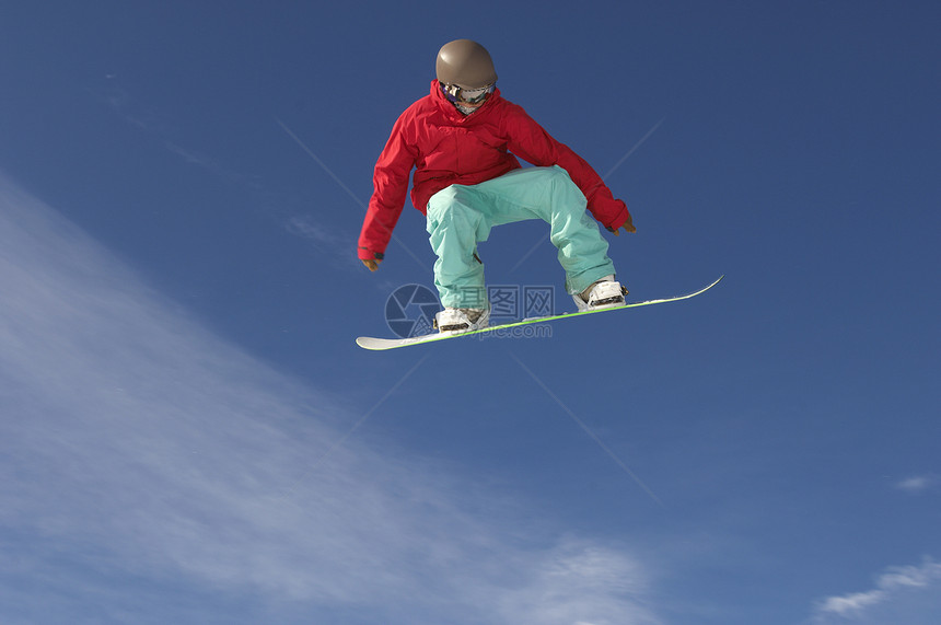 冬季衣服中年轻男性滑雪运动员的低角度视角跳过天空图片