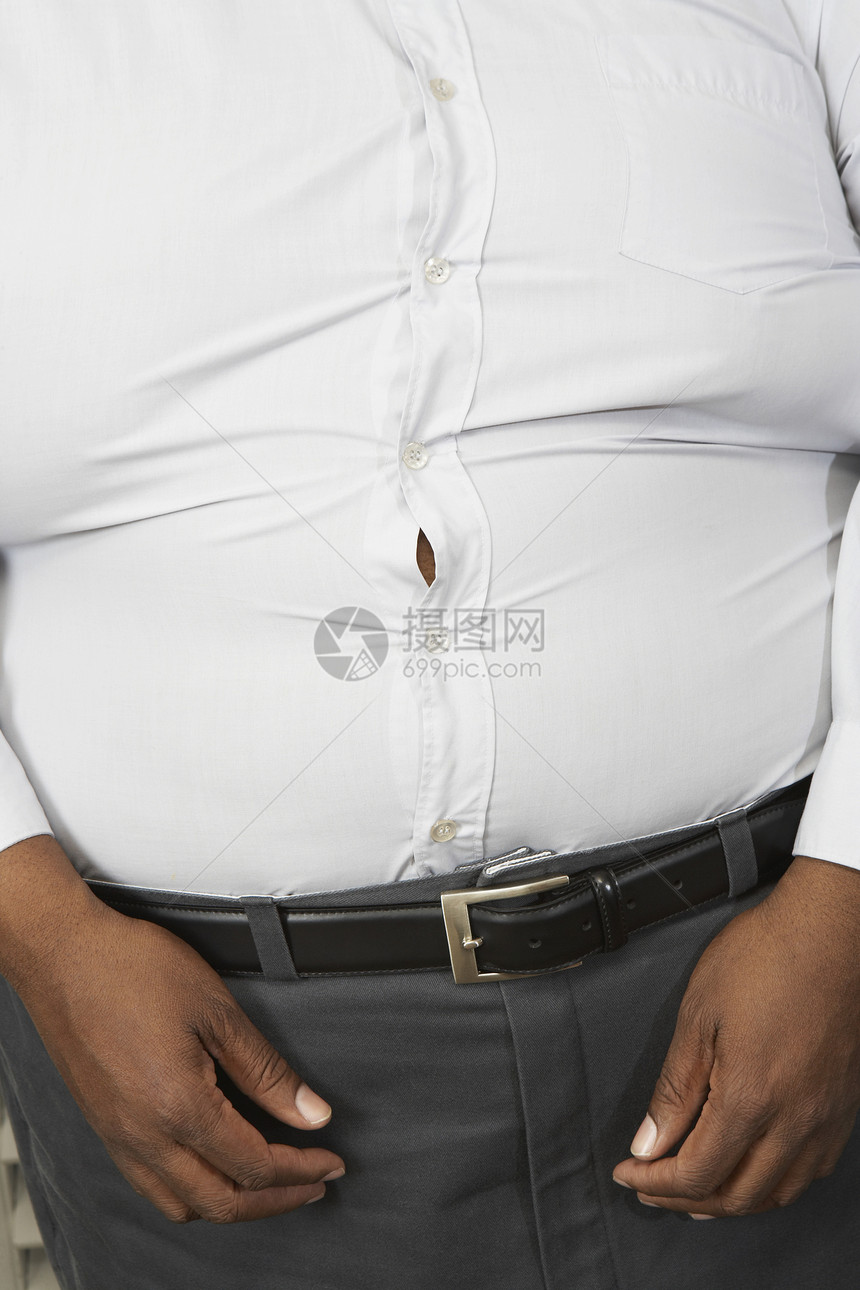 身穿紧装白色白衬衫的肥胖男子的中产体图片