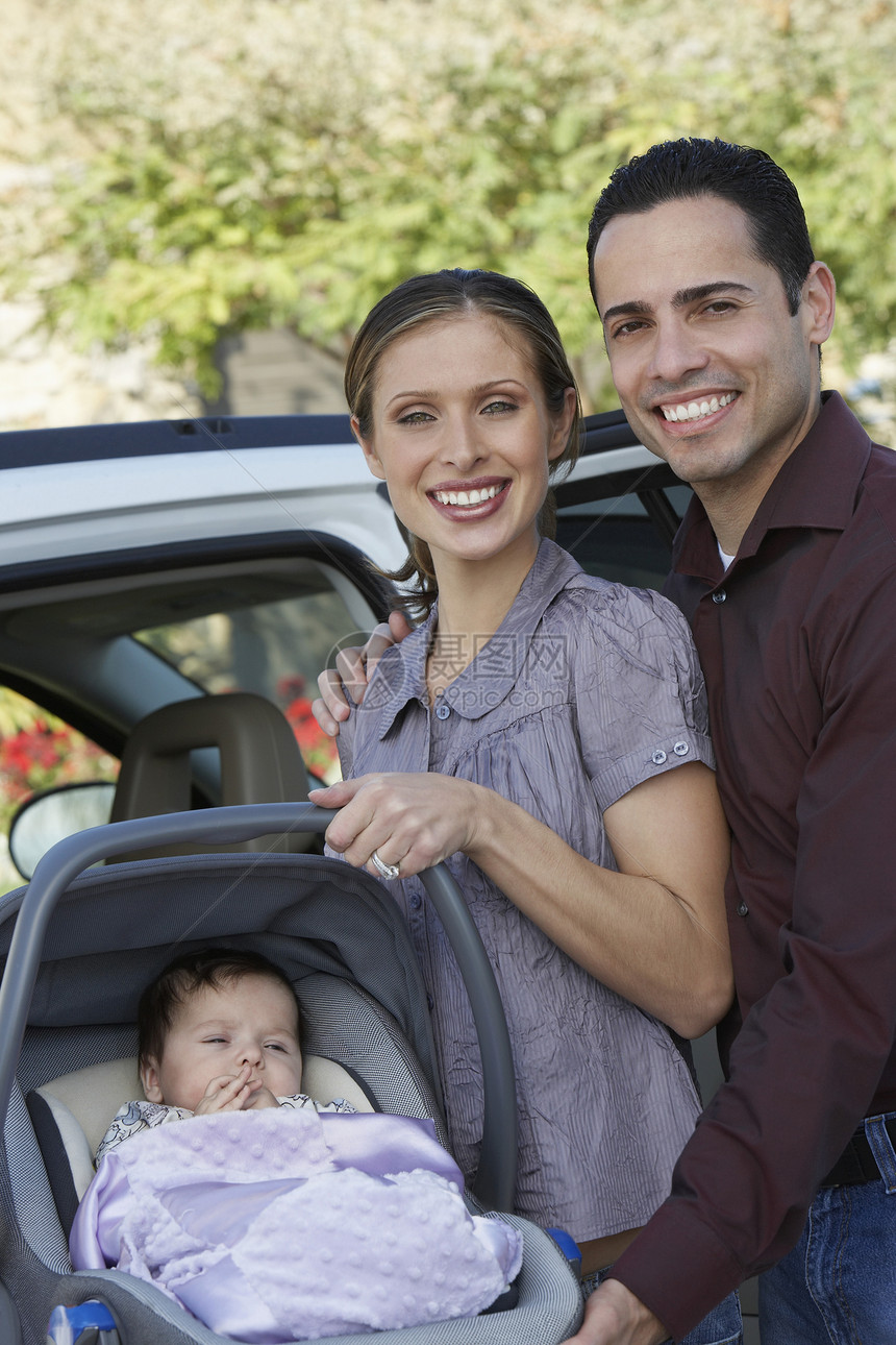 快乐的年轻夫妇的肖像 婴儿乘车在载体中图片