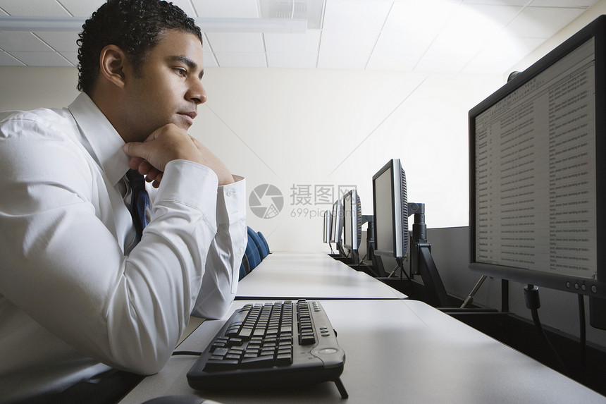 商务人士的侧面视线 在电脑实验室坐着时用手看下巴 故意看着屏幕图片