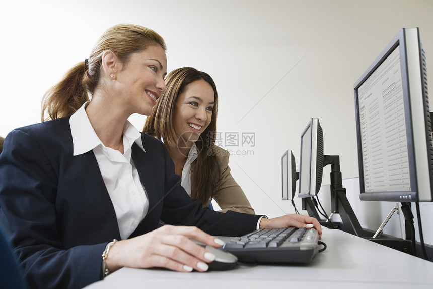 两位不同种族的商业同事在电脑上一起工作图片