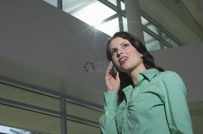 在办公楼使用移动电话的女商业妇女 企业图片