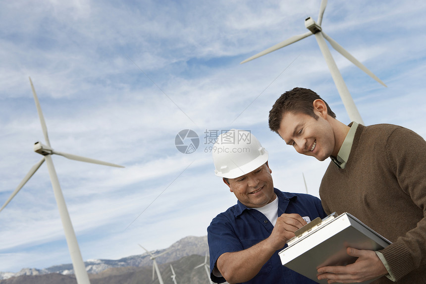 多族裔工程师在风力农场一起工作图片