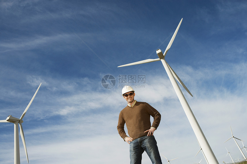 在风力农场穿着硬帽的自信男性工程师低角度视角视图图片