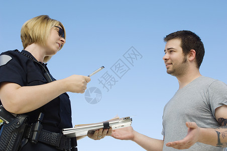 警察与小偷女警官与年轻男子在蓝天上签票的女警官背景