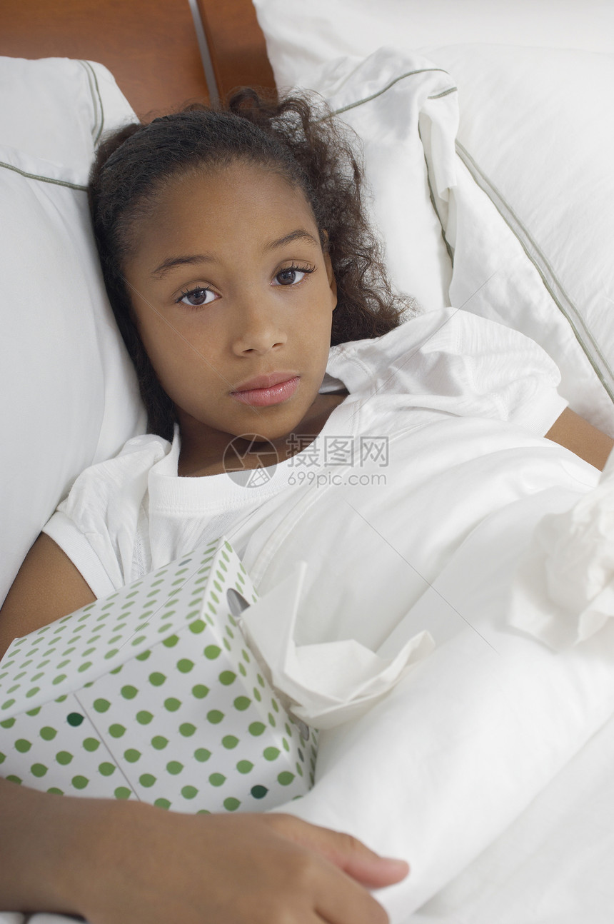 一个在床上放纸箱的非裔美国女孩的肖像图片