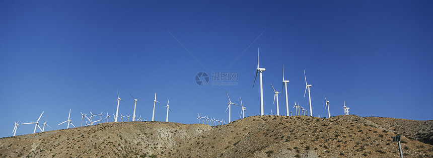 一组对准的风车反蓝天图片