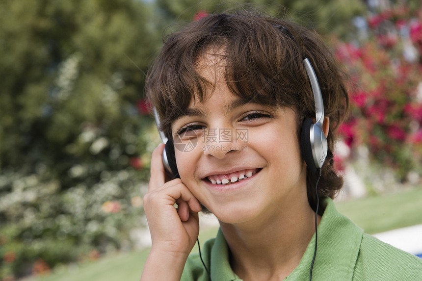 小男孩听耳机微笑孩子们设备享受表情乐趣青少年听力消遣音响图片