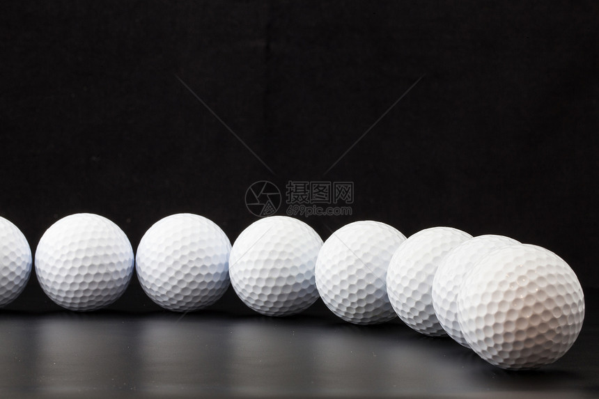 黑色背景的高尔夫球木头运动圆圈桌子材料图片