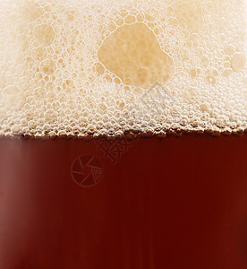 把啤酒杯和泡沫一起贴上泡沫状气泡发泡饮料啤酒酒吧黄色白色玻璃干杯背景图片