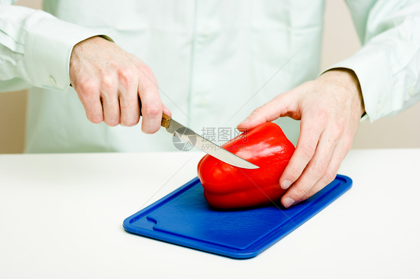男人的手切红胡椒厨房食物男性桌子木板白色砧板烹饪沙拉蔬菜图片