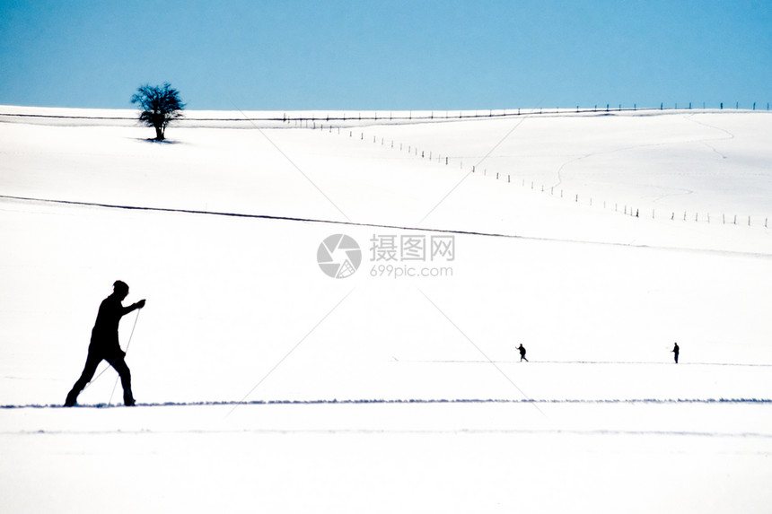 跨国家滑雪者在露天大雪中滑雪成年人踪迹国家两极运动蓝色享受季节天空娱乐图片