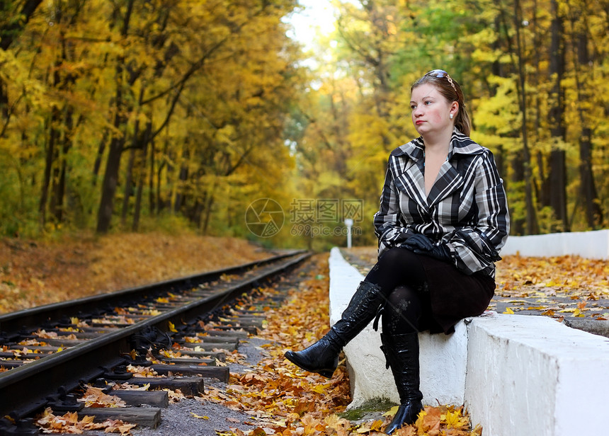 妇女坐在铁路附近图片