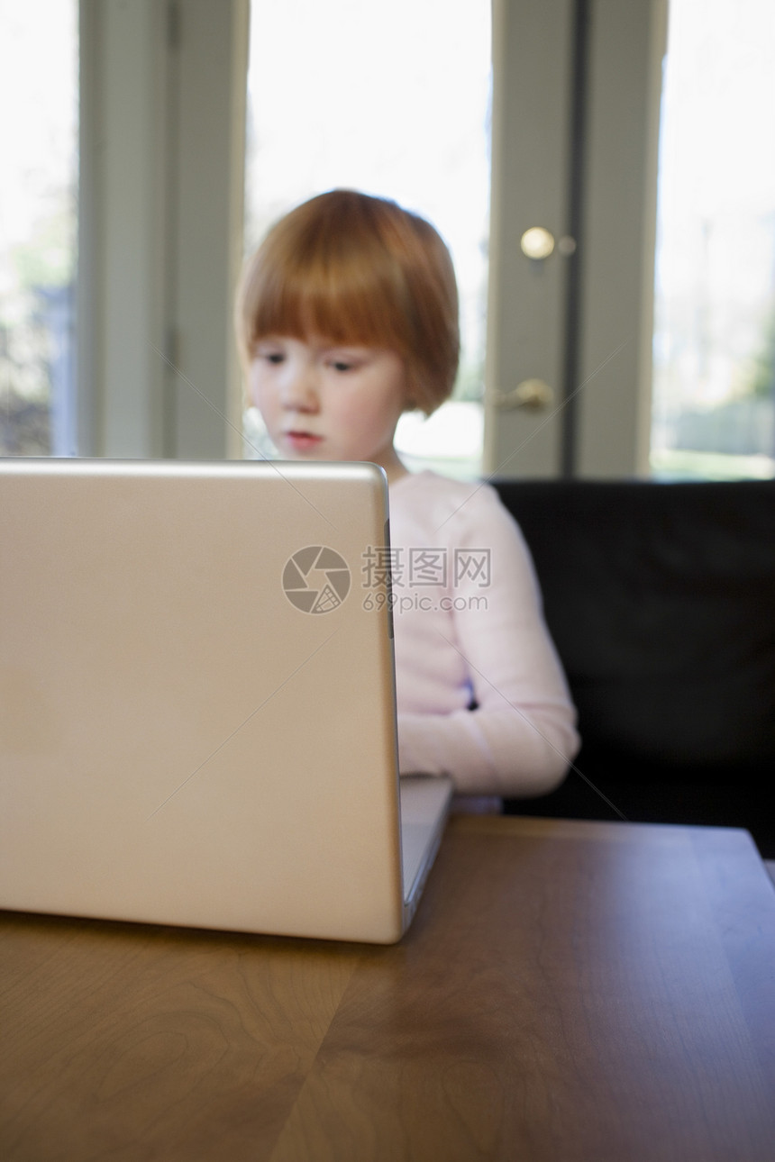 使用集中型笔记本电脑的少女5656女孩互联网安全沉思服装桌子黄色一人童年阅读图片