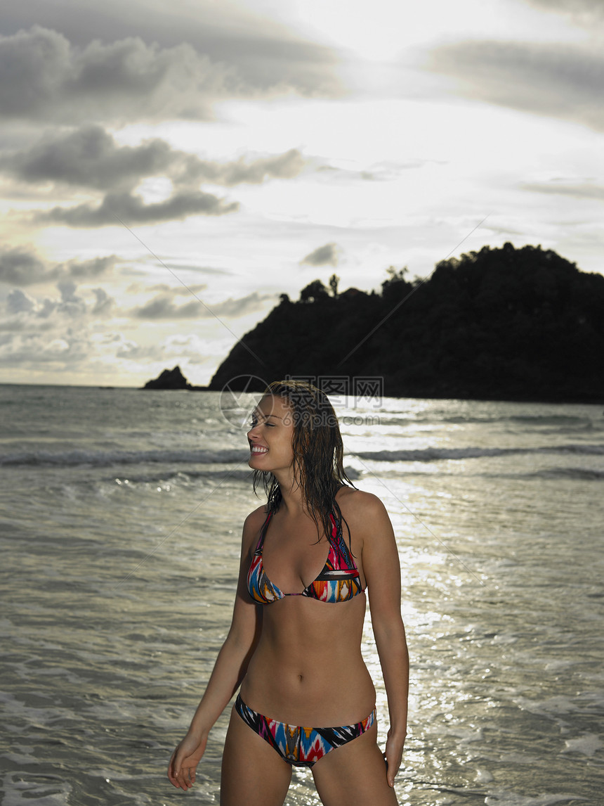 海滩的年轻女子成年人用品海洋服装游泳衣日落享受美女年轻人空闲图片