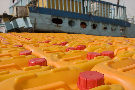迪拜UAE UAE烹饪油等待装上一艘单桅帆船前往伊朗或索马里橙色塑料黄色对象背景图片