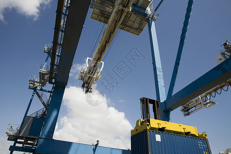 在天空对面的靠岸起重机低角度视图Limassol 塞浦路斯货运码头运输出口卸载货物加载商业工程水平背景图片