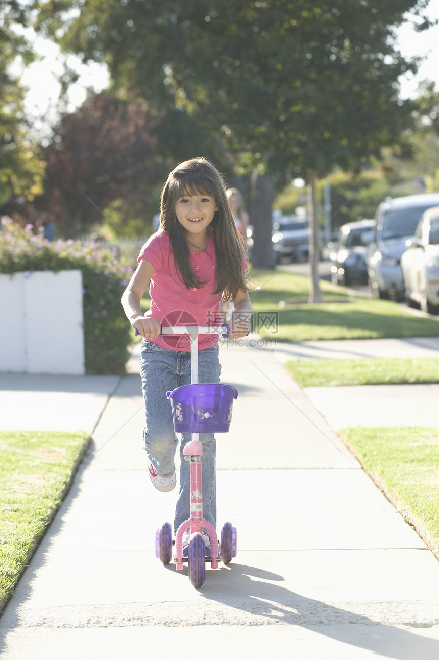 骑摩托车的女孩快乐长发幸福运输乐趣孩子服装棕色微笑闲暇图片