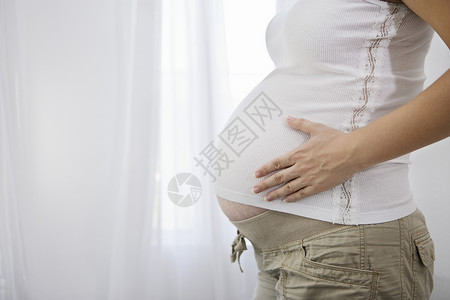 孕妇站立在窗口中间区间高清图片