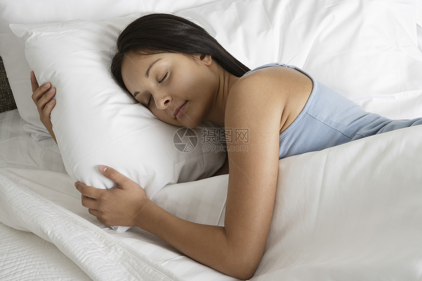 一位在床上睡觉的年轻女子的高视被单午睡就寝睡眠卧室美丽女士枕头时间房子图片