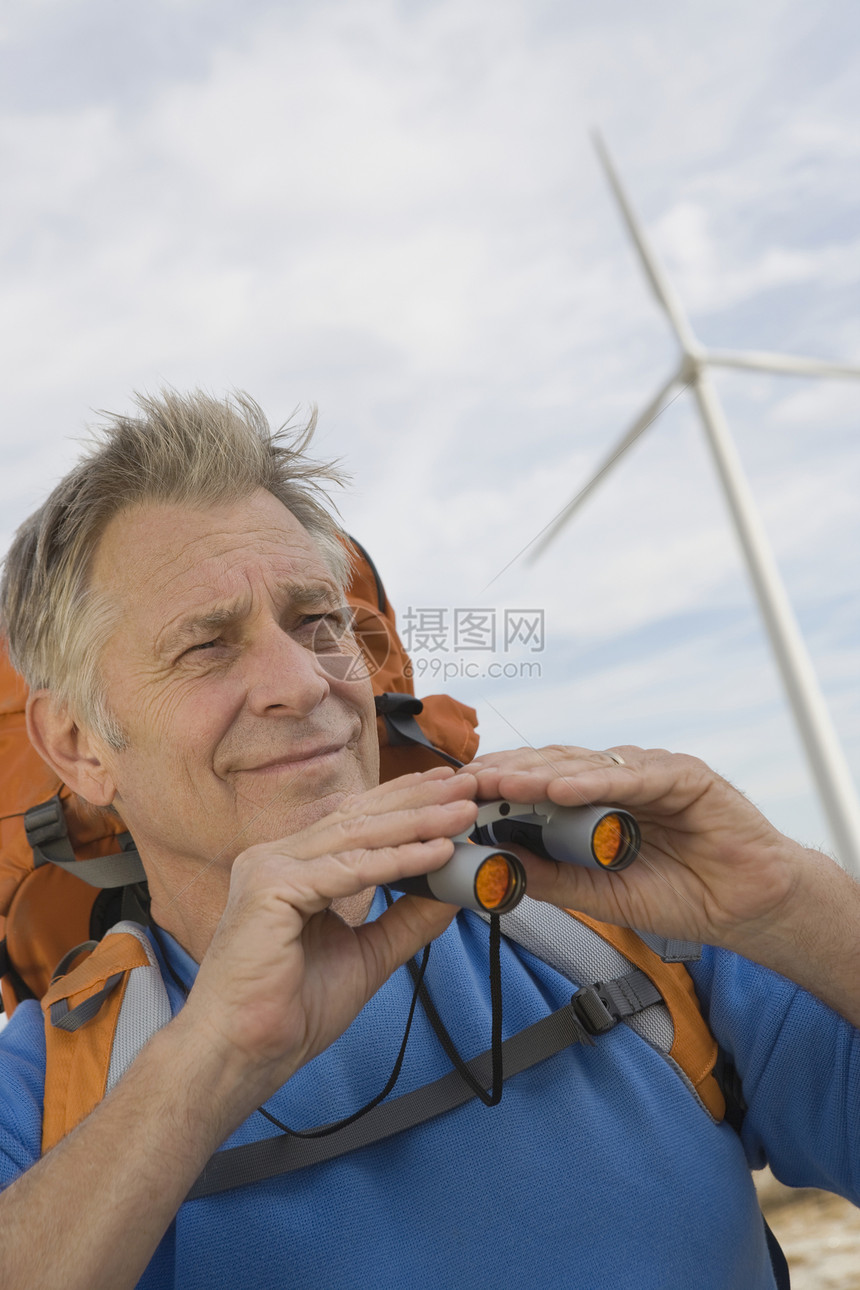 在风力农场附近带背背包的老年人蓝色退休远足能源生态旅游环境问题风能望远镜涡轮机自由图片