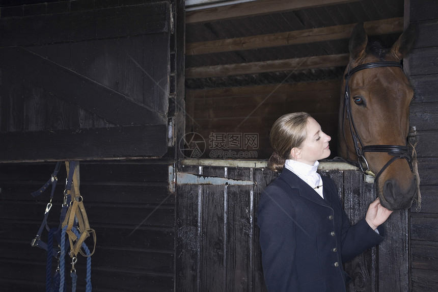 骑马的女性骑马者 马匹稳定夹克女孩友谊工作木头水平团结动物图片
