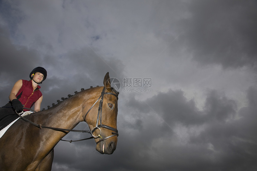 坐在棕色马匹上的女性骑马女骑士一人缰绳手套友谊幸福主题骑马帽享受视图双腿图片