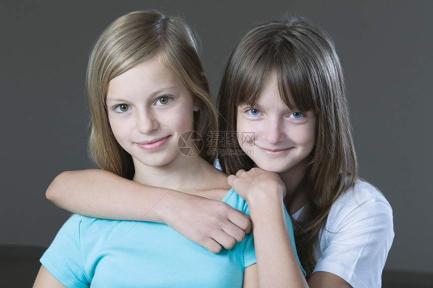 两个女孩微笑的演播室肖像头肩个人团结青春期快乐女孩拥抱童年长发友谊图片